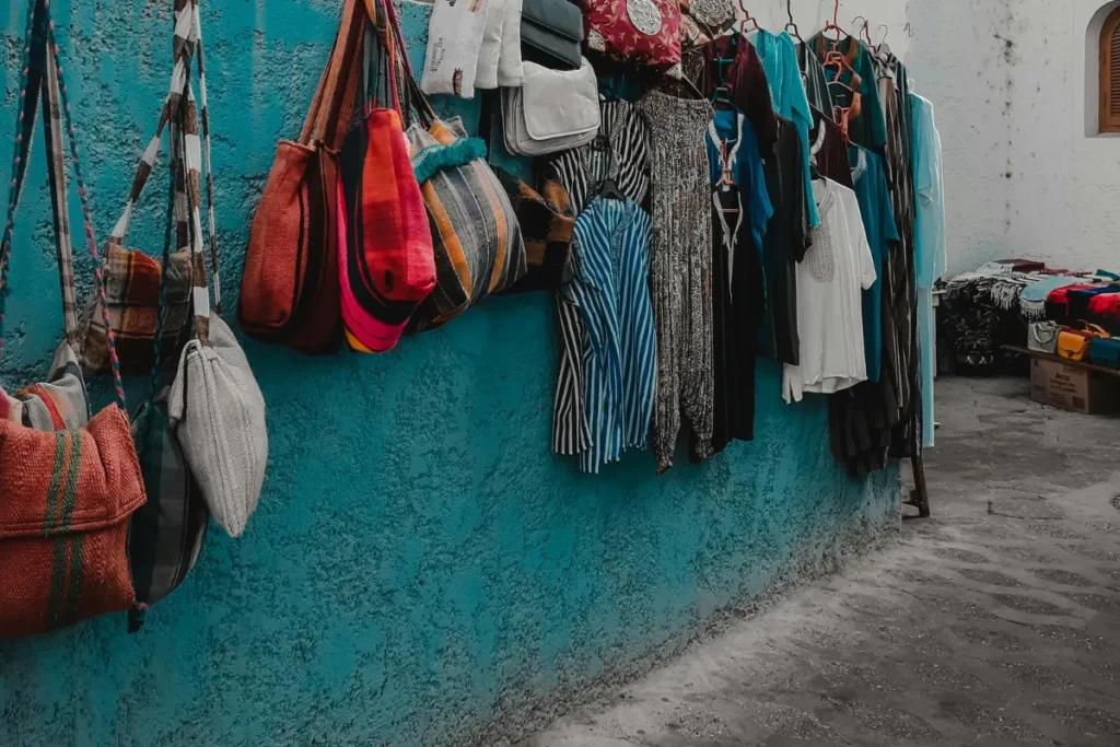 A display of moroccan handbags and clothing such as jabador and handora hanging on a wall