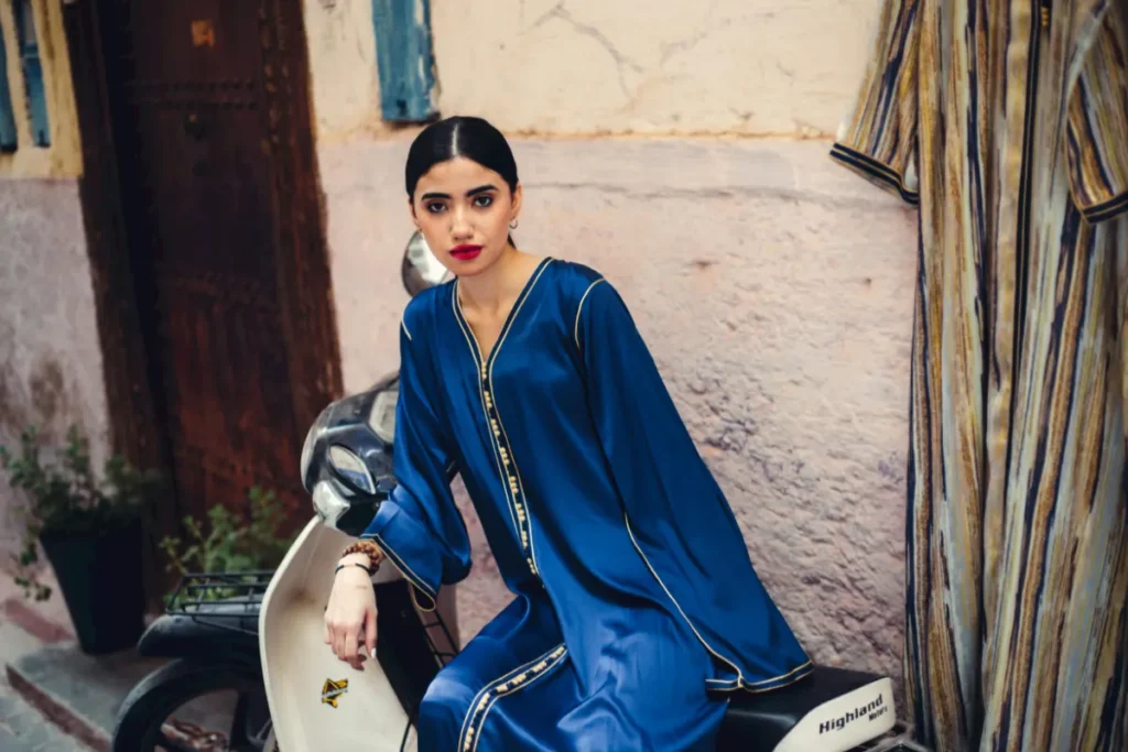 A women modeling a Moroccan blue silk caftan with handmade sfifa